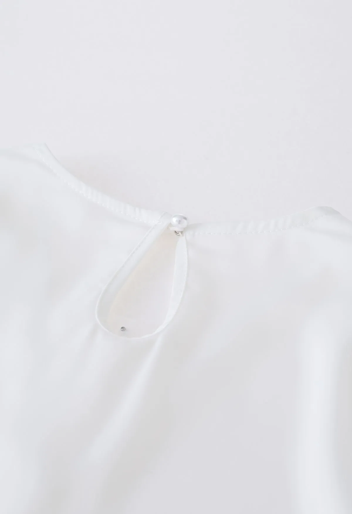 Haut en satin à col en V et maille perlée en blanc